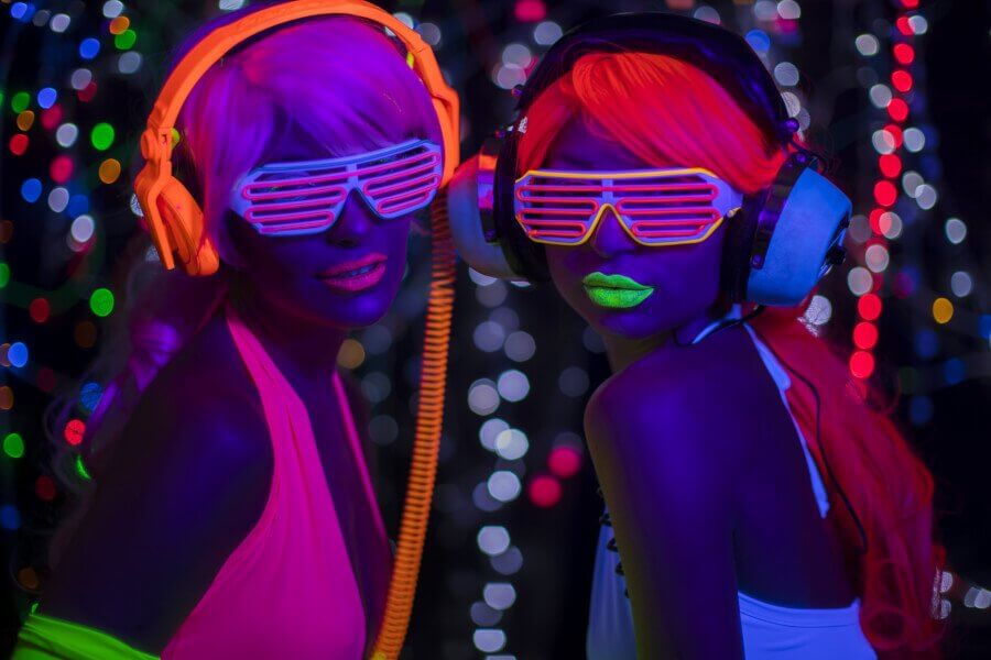Soiree fluo : 2 femmes portant un déguisement fluo et écoutant de la musique lors d'une soirée fluo