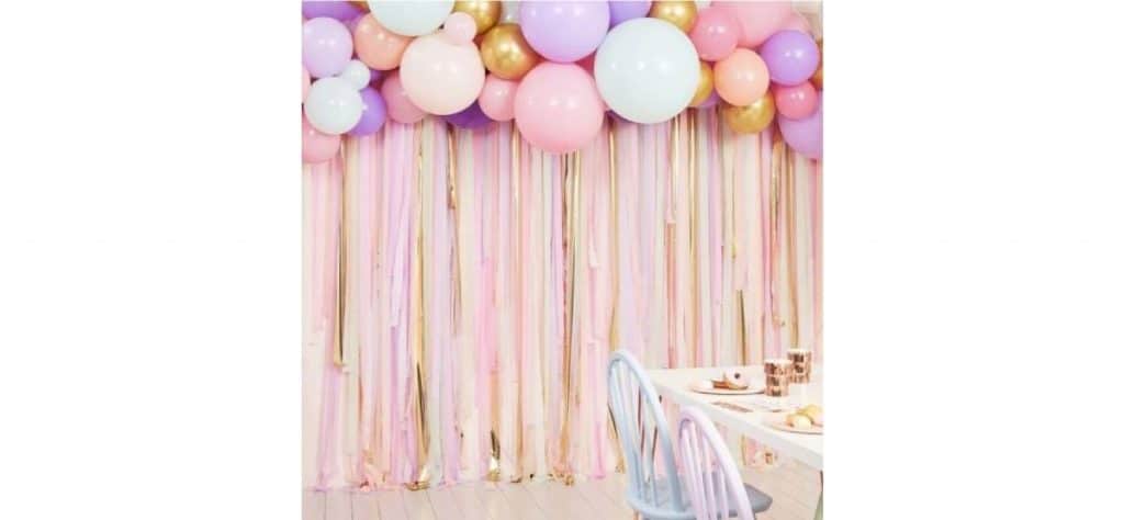 Arche de ballons pastel et rideau de papier crépon